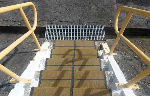 Escalera industrial con huella antideslizante y pasamanos de seguridad