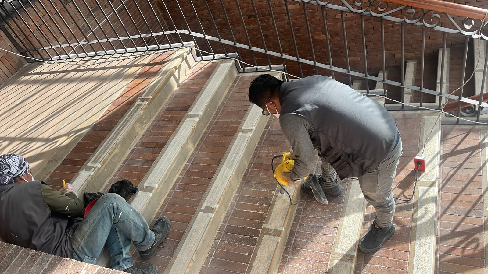 Equipo técnico instalando sistema antideslizante en escalera de ladrillo